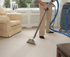 Carpet cleaning professional removing dirt and stains with a hot-water extraction tool in a home, Fort Worth, TX.