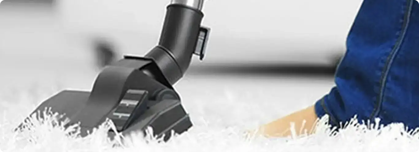 Close-up of a professional vacuuming a white carpet in Arlington.